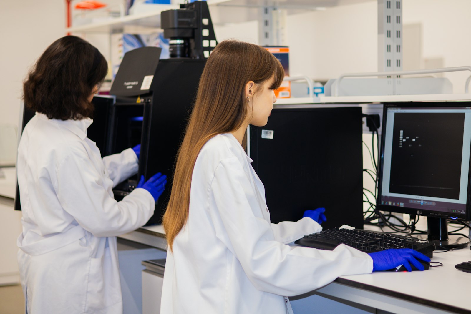 Image d'illustration — deux chercheurs analysant des données dans un laboratoire ; la photo n'illustre pas ArisGlobal ni Dassault Systèmes.